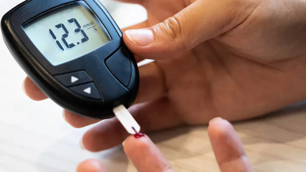 Close-up of hands using a blood glucose meter showing a reading of 12.3 mmol/L, illustrating blood sugar monitoring relevant to GLP-1 research