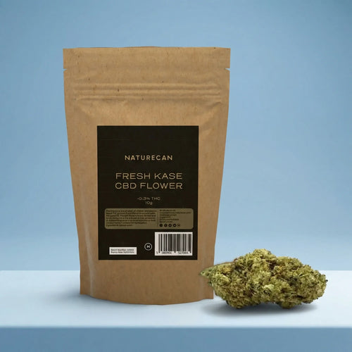 Naturecan Fresh Kase CBD Flower lifestyle – kraft paper pouch with dark label on light blue background, with CBD flower bud displayed beside it