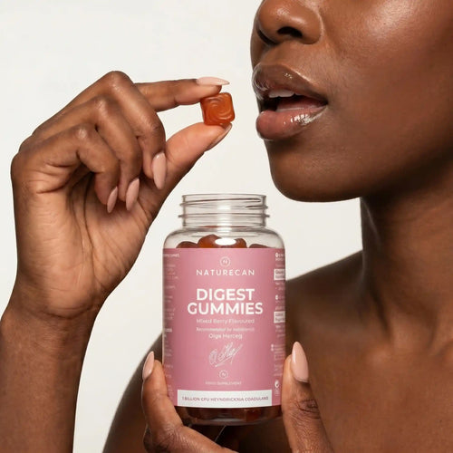 Person holding a bottle of Naturecan Digest Gummies with a neutral background