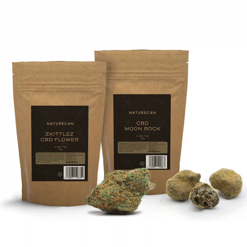 Naturecan Premium CBD Flower Bundle – two kraft paper pouches: Zkittlez CBD Flower and CBD Moon Rock, each 10g with 0.3% THC, with orange-trichome flower bud and rounded moon rocks beside them
