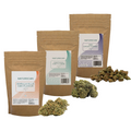 Four brown kraft stand-up pouches of Naturecan CBD flower in different strains, arranged in a fan shape with several green and beige buds scattered in front on a plain white background.