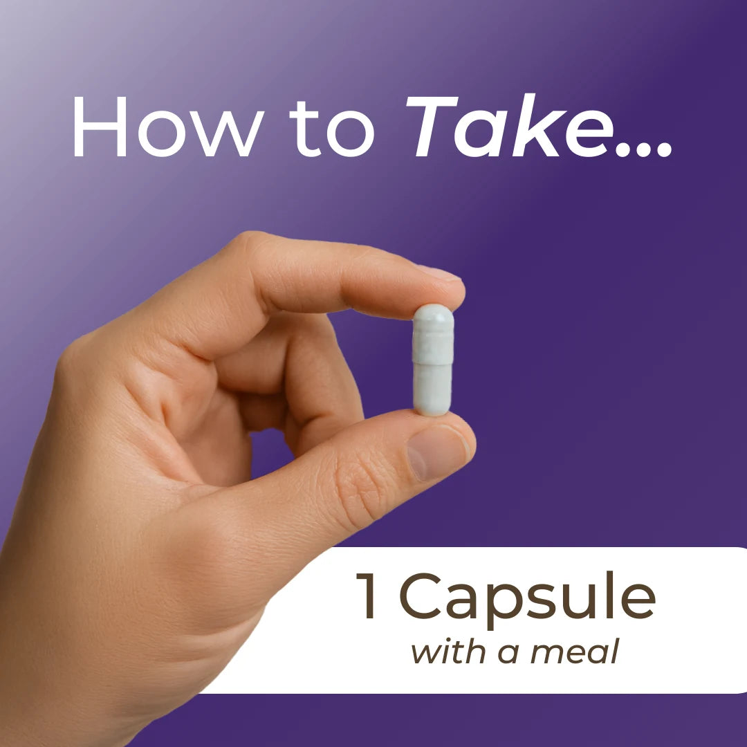 Hand holding a capsule with text on how to take it, against a purple background